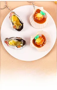 Vue détaillée de porte-clés réalistes en PVC d'huîtres et de coquilles Saint-Jacques sur plat