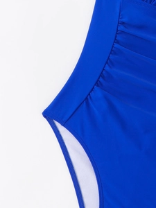 Detailed close-up of blue halter swimsuit featuring ruched fabric and high-quality stitching