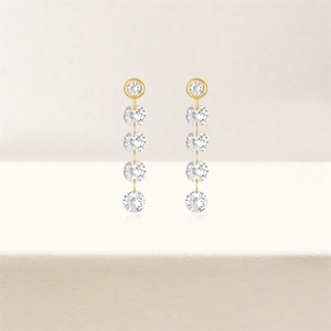 Detail of gold drop earrings featuring five vertically linked round-cut sparkling stones