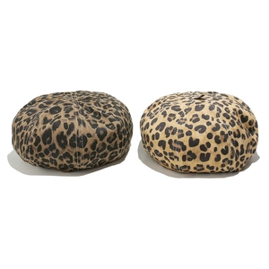 Detail of leopard print berets in brown and beige tones on a clean white background