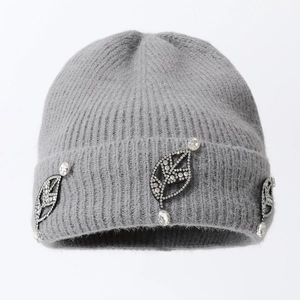 Close-up of light grey knit beanie with elegant crystal leaf jewelry embellishments