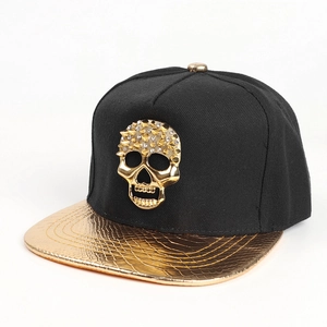 Détail d'une casquette hip hop avec tête de mort dorée et visière à motif serpent