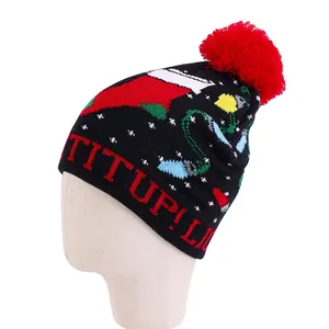 Christmas knit beanie featuring festive jacquard patterns and a large red faux fur pom-pom