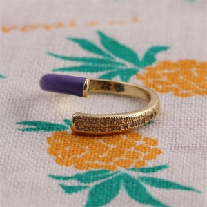Detailed close-up of a gold-plated adjustable ring with purple enamel and small diamonds