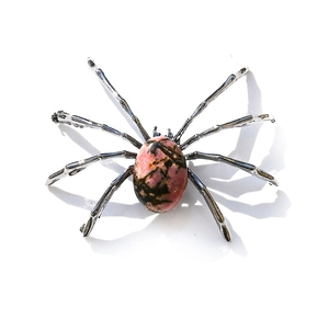 Detailed top view of a spider-shaped figurine with natural pink rhodonite stone body