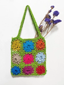Close-up of handmade crochet tote bag featuring multi-color floral granny square patterns