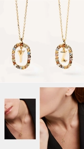 Detail of gold letter Y and Z necklaces featuring colorful crystal-encrusted oval pendants