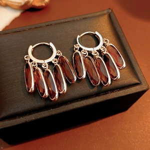 Gros plan de boucles d'oreilles vintage en argent avec cinq gemmes ovales rouge vin
