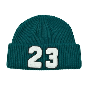 Detalle de la textura de punto acanalado grueso y el bordado blanco número 23 en el gorro