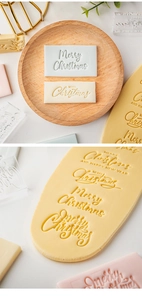 Detailed view of Merry Christmas embossed patterns on cookie dough using festive stamp tools
