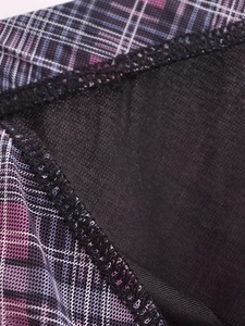 Makroaufnahme von lila-rosa kariertem Netzstoff mit schwarzem Futter und Overlock-Naht