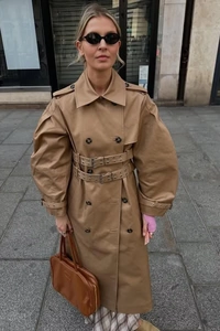 Detail view of khaki double-breasted trench coat with unique double belt and wide sleeves