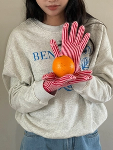 Detalle de guantes de punto a rayas rojas y blancas con función de pantalla táctil