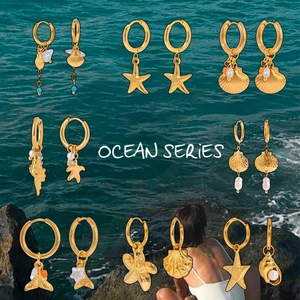 Λεπτομέρεια από κρίκους ocean series 18K χρυσού με κρεμαστά αστερία, κοχύλια και πέρλες
