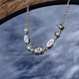 Punk Y2K silver choker with Riley enamel plaques and butterfly diamond pendant on mirror