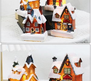 Detailed view of glowing resin Christmas miniature houses with warm LED lighting and fake snow