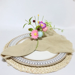 Detail of Easter napkin ring with colorful flowers and berries on a linen napkin