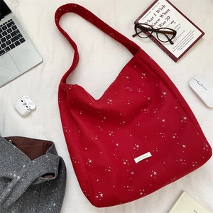 Dettaglio borsa shopper in lana rossa con stelle di paillettes argentate ed etichetta