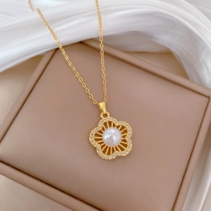 Detail of gold necklace with a pearl flower pendant on silk in a gift box