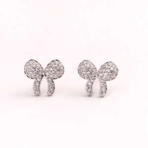 Elegant silver bow earrings with sparkling pink cubic zirconia in professional studio lighting