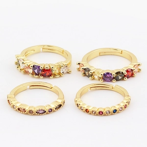 Set de cuatro anillos abiertos bañados en oro de 18K con circonitas de colores variados
