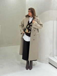 Detail shot of oatmeal wool coat fabric texture and minimalist tailoring design