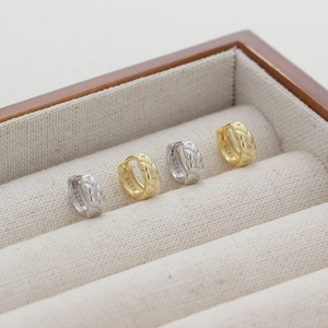 Close-up of gold and silver S925 sterling silver hoop earrings with twisted rope texture