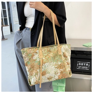 Green and gold floral jacquard tote bag with leather handles shown in a lifestyle setting