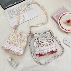 Detail view of quilted cotton bucket bag with lace trim and heart cutouts in floral patterns