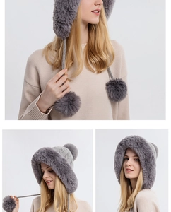 Detail of grey knitted trapper hat with soft faux fur lining and large pom-pom accents