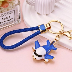 Detail of blue airplane keychain with rhinestones and blue woven leather strap