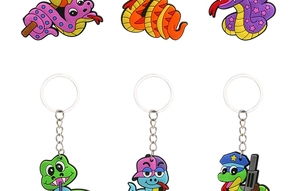 Detail view of six colorful PVC cartoon snake keychains with metal rings on white base