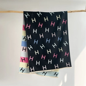 Close-up of cashmere-like shawl featuring luxury H pattern and colorful stripe details