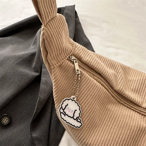 Beige corduroy crossbody dumpling bag with cute cartoon puppy charm accessory