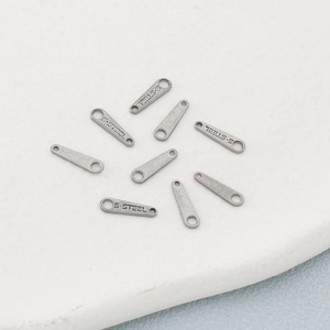 Polished silver stainless steel chain link charms with S.STEEL engraving on white background