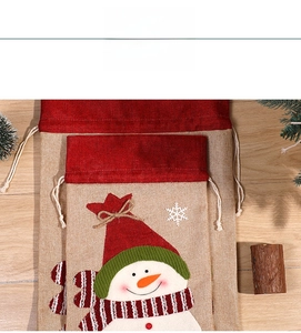 Detail of burlap Christmas drawstring gift bags with snowman applique and festive embroidery