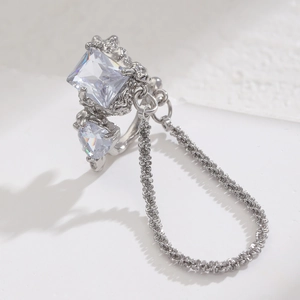 Detail of silver ring with square and heart crystals and a fine decorative chain