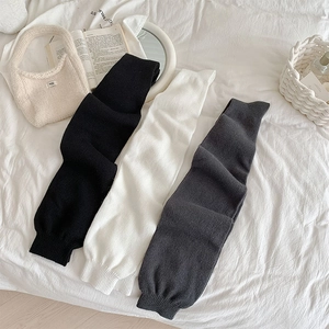Detailed knit texture of thick over-the-knee socks in black, white and grey colors