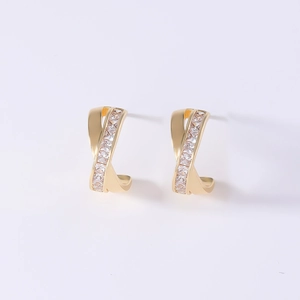 Macro detail of gold-plated geometric earrings with shimmering cubic zirconia inlay