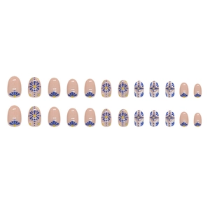 Short oval press-on nails with blue floral pattern and yellow accents on nude base