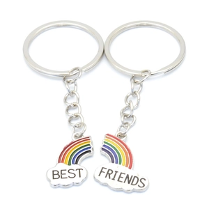 Detail of colorful rainbow cloud keychains forming the phrase BEST FRIENDS on white background