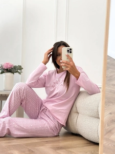 Pink heart print long sleeve loungewear set with pink plaid trousers in a cozy indoor setting