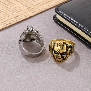 Gothic skull and snake ring set in gold and silver finish on vintage background