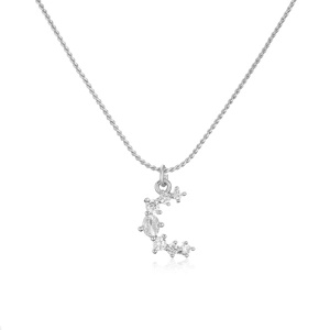 Macro shot of silver crescent moon pendant with sparkling zircon stones and cable chain