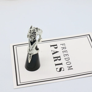 Gothic silver skull armor ring with movable joints and punk rock aesthetic on stand
