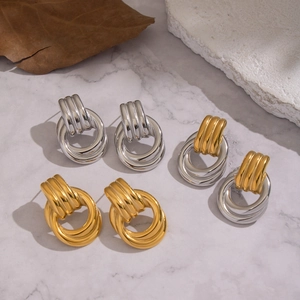 Detailed view of triple-layered geometric stud earrings in gold and silver finish