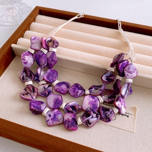 Detailed view of bohemian purple shell layers with handcrafted silver wire wrapping