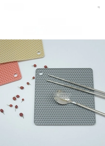 Detail of hexagonal honeycomb silicone placemats in grey, pink and beige colors