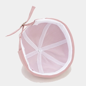 Pink cotton miki hat with N embroidery and adjustable strap in a top-down interior view