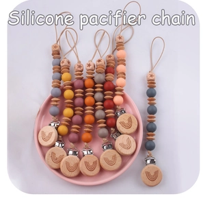 Close-up of silicone pacifier chains with beech wood clips in Morandi color palette
